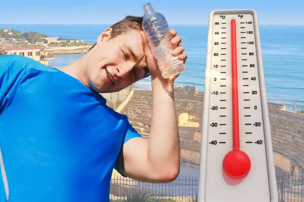 Home amb samarreta blava refrescant-se amb una ampolla d’aigua al costat d’un termòmetre que marca una temperatura alta en un entorn costaner