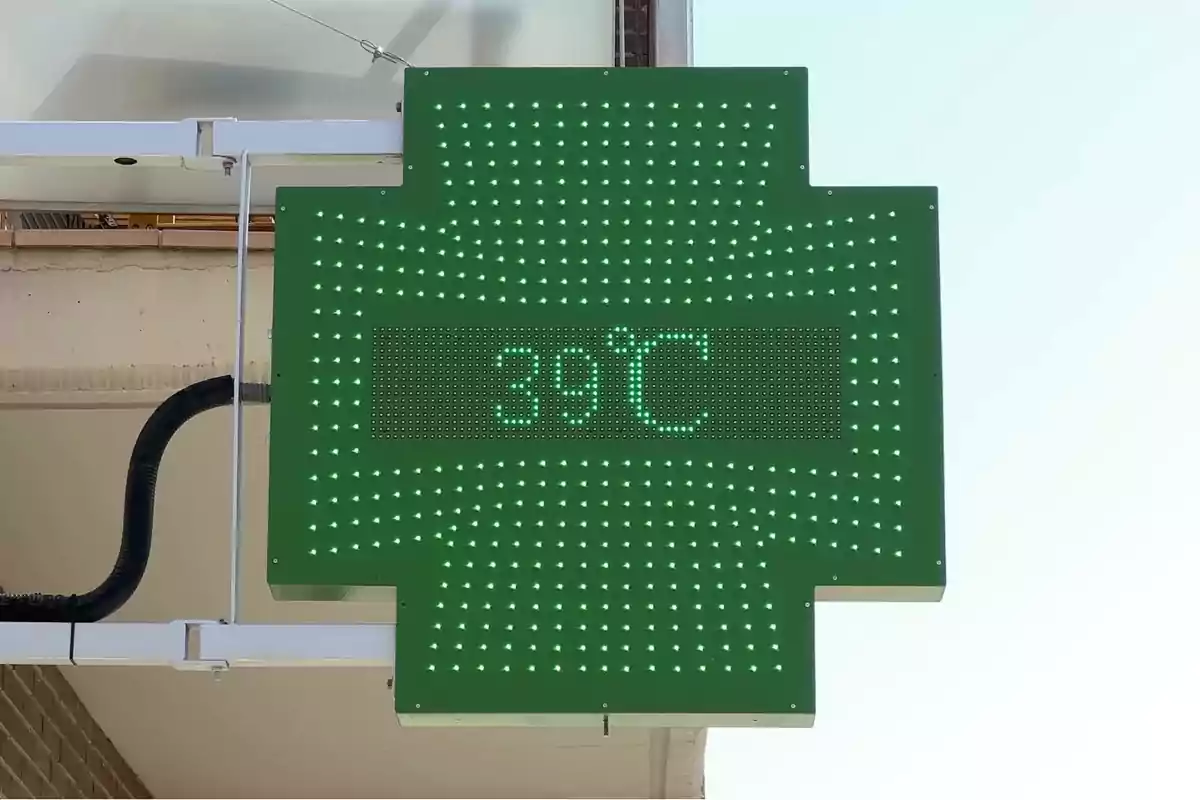 Rètol verd de farmàcia amb llums LED que mostra una temperatura de 39 graus Celsius Rètol verd de farmàcia amb llums LED que mostra una temperatura de 39 graus Celsius