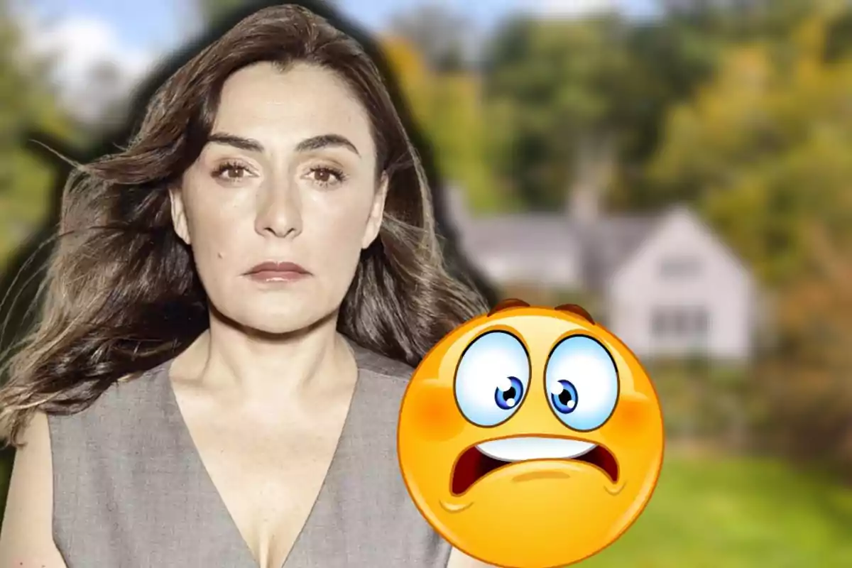 Dona de cabells castanys amb expressió seriosa davant d’una casa desenfocada i un emoji de cara espantada en primer pla