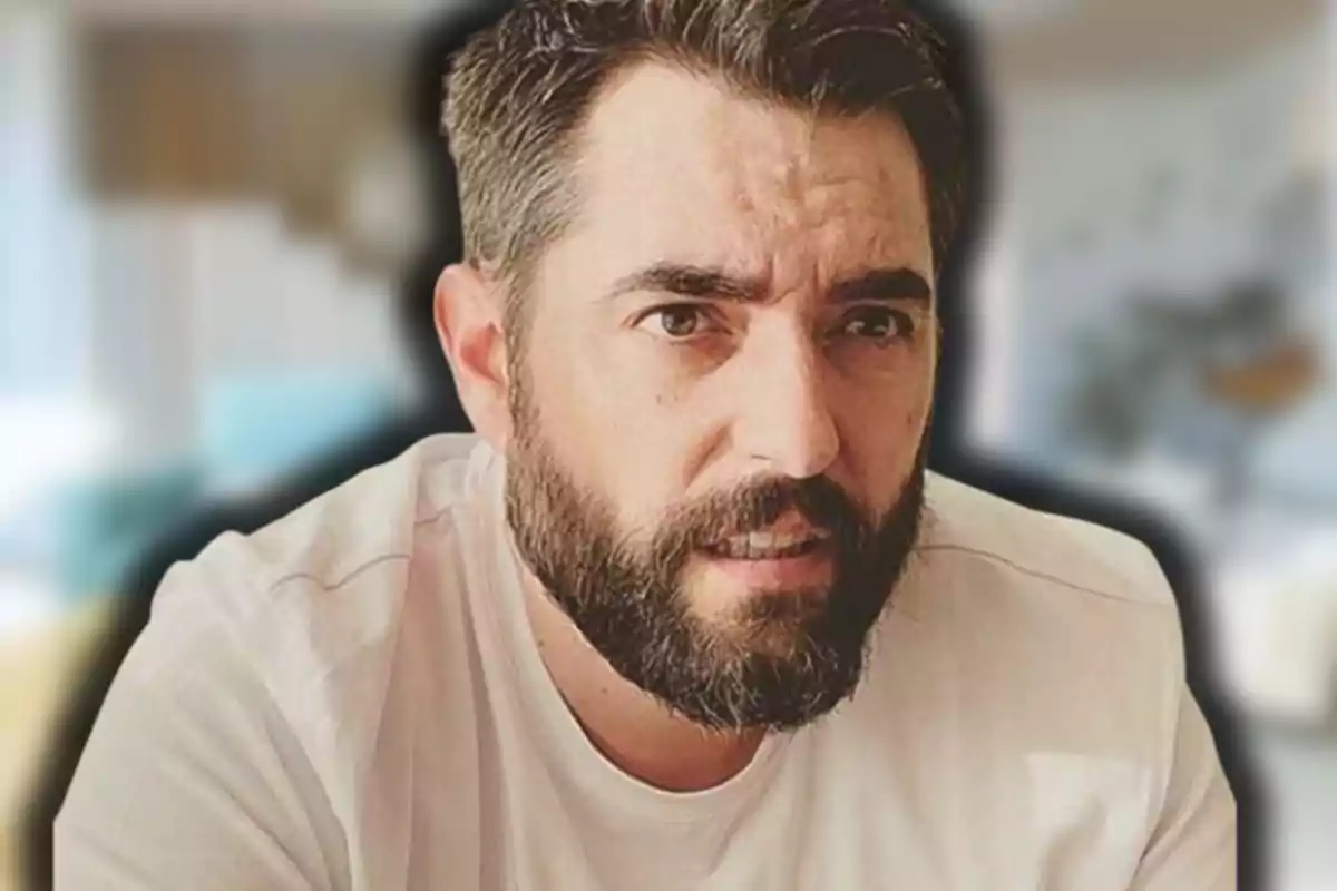 Home de barba i cabell curt amb samarreta clara en un entorn desenfocat