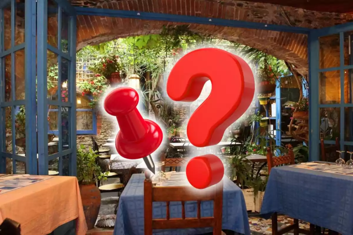 Restaurant amb taules cobertes amb estovalles blaves i decoració de plantes, amb una agulla vermella i un signe d’interrogació grans al centre