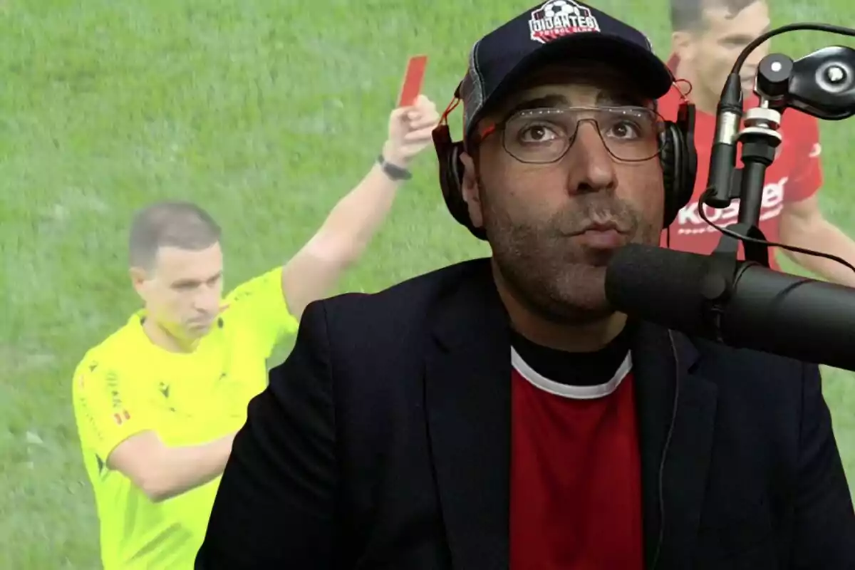 Hombre con gafas y gorra hablando frente a un micrófono mientras al fondo se ve a un árbitro mostrando una tarjeta roja en un partido de fútbol