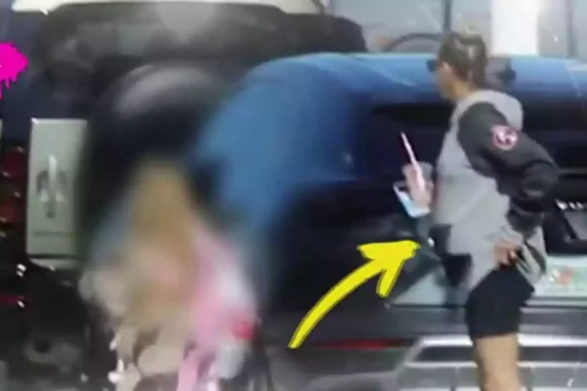 Anna Kournikova dreta al costat d’un cotxe sostenint una beguda amb canyeta i portant ulleres de sol, amb una fletxa groga assenyalant-la i una figura desenfocada en primer pla Anna Kournikova dreta al costat d’un cotxe sostenint una beguda amb canyeta i portant ulleres de sol, amb una fletxa groga assenyalant-la i una figura desenfocada en primer pla