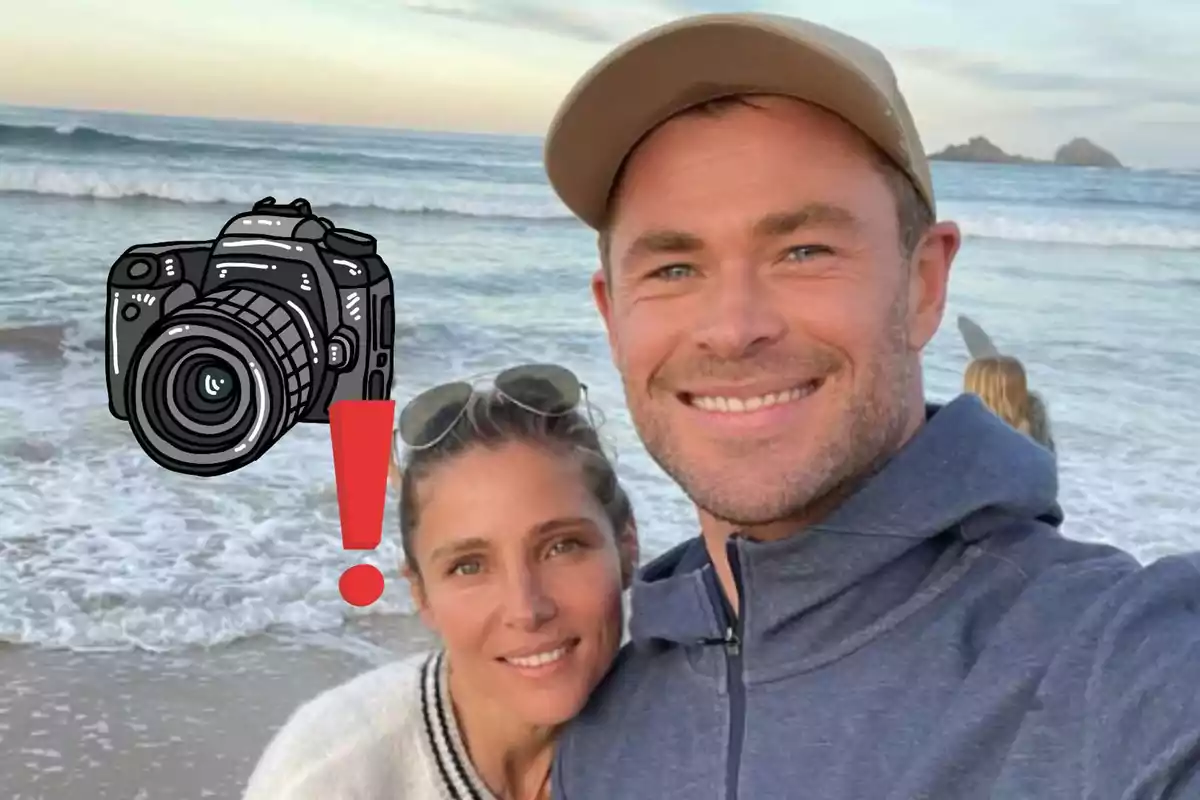 Parella fent-se una selfie a la platja al capvespre amb un dibuix d’una càmera i un signe d’exclamació sobre la imatge