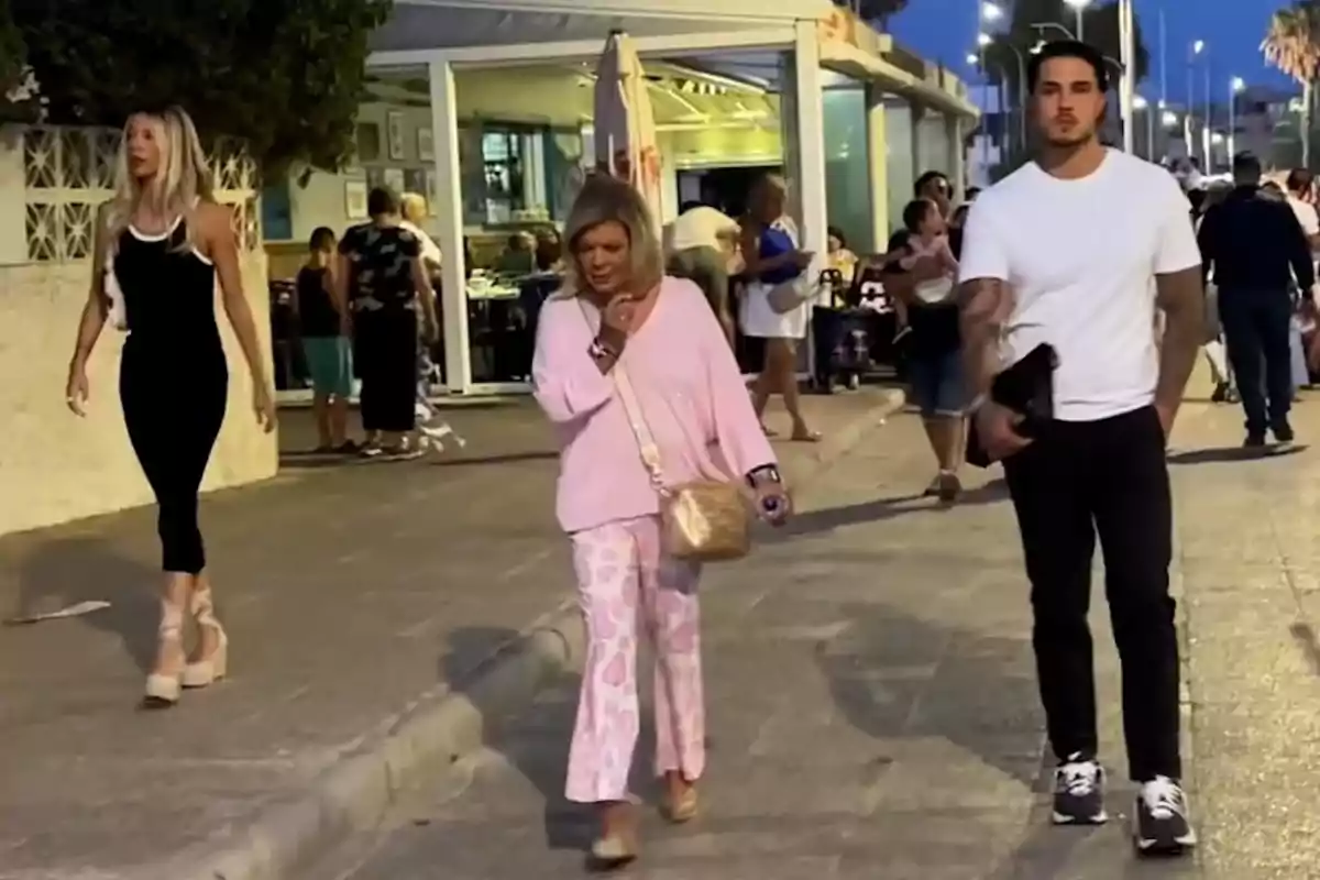 Alejandra Rubio, Terelu Campos y Carlo Costanzia caminando por una calle peatonal al atardecer con un restaurante al fondo y varias personas en el entorno Alejandra Rubio, Terelu Campos y Carlo Costanzia caminando por una calle peatonal al atardecer con un restaurante al fondo y varias personas en el entorno