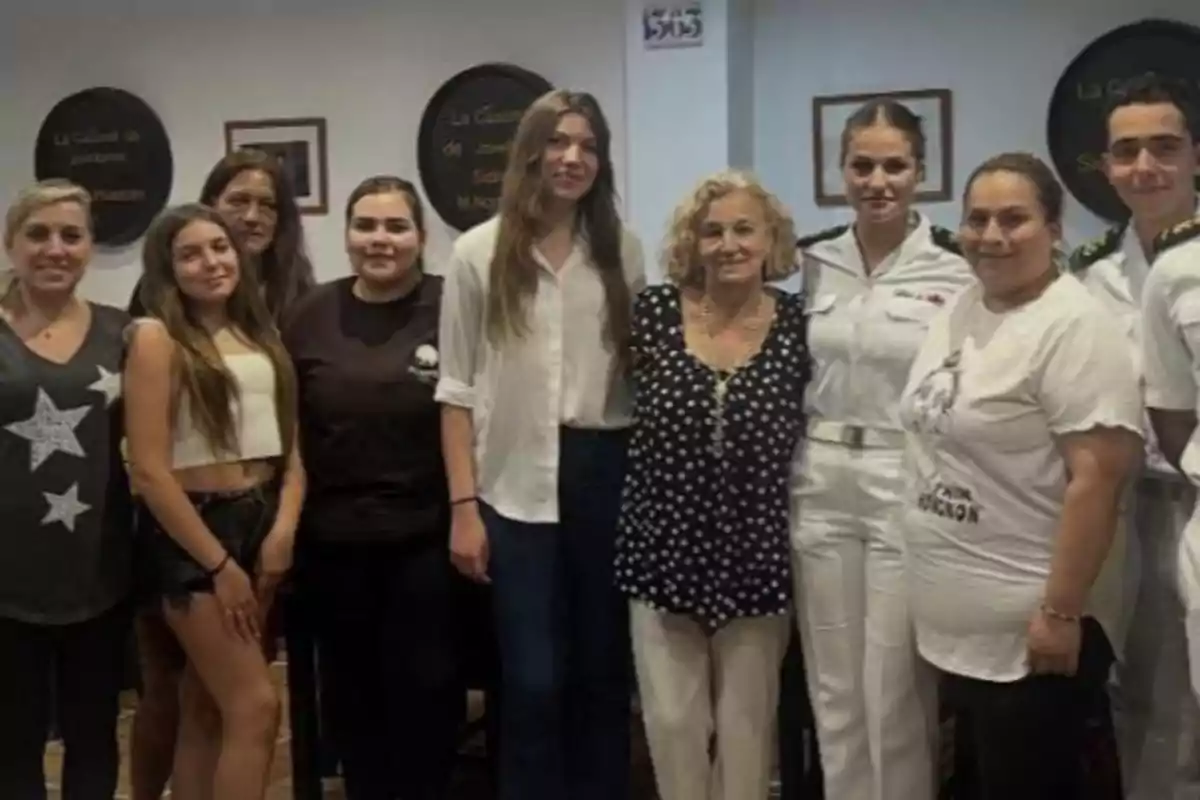 Grup de persones posant juntes en un interior, algunes amb uniforme blanc i altres amb roba casual, totes somrient cap a la càmera. Grup de persones posant juntes en un interior, algunes amb uniforme blanc i altres amb roba casual, totes somrient cap a la càmera.