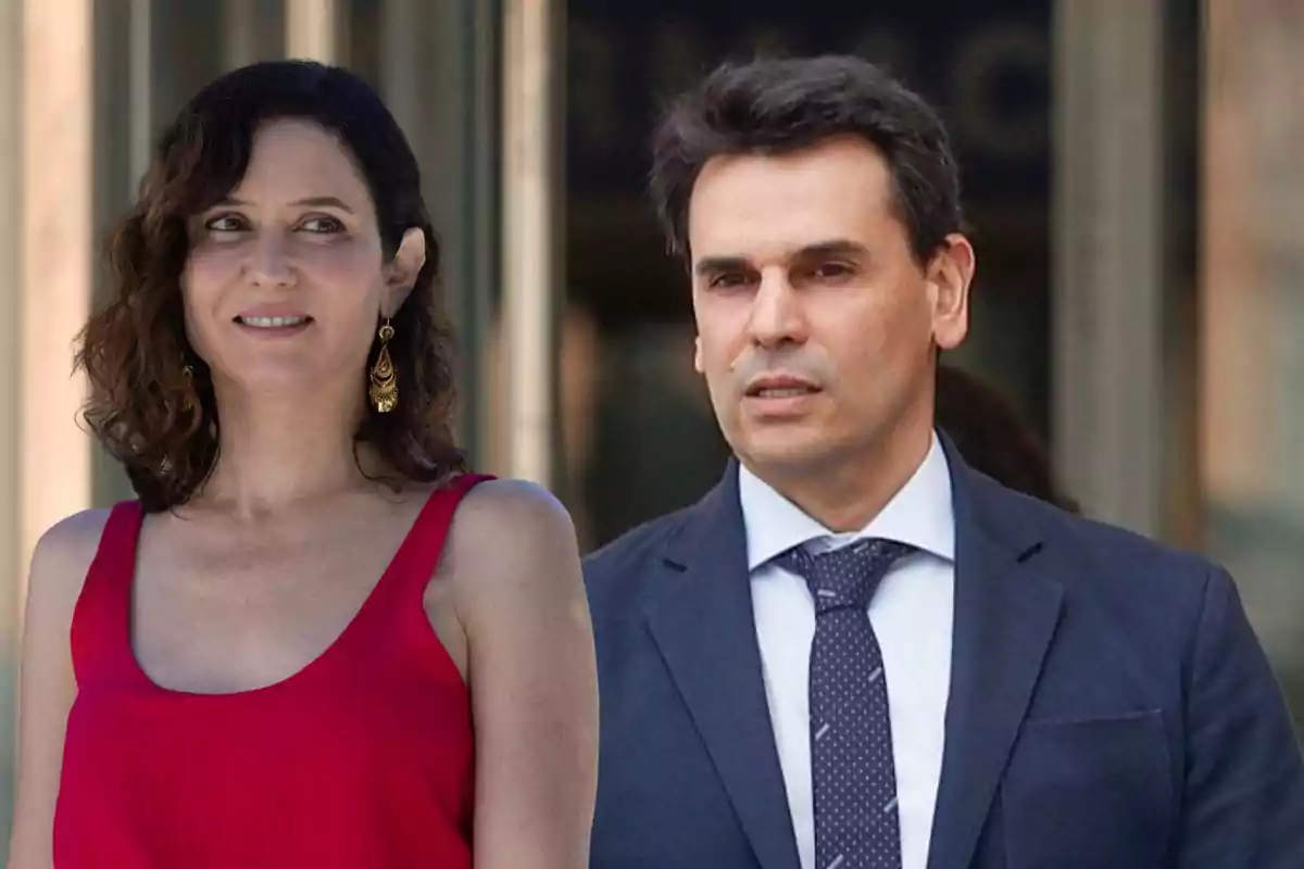 Una dona amb vestit vermell i un home amb vestit fosc posen junts en un entorn urbà