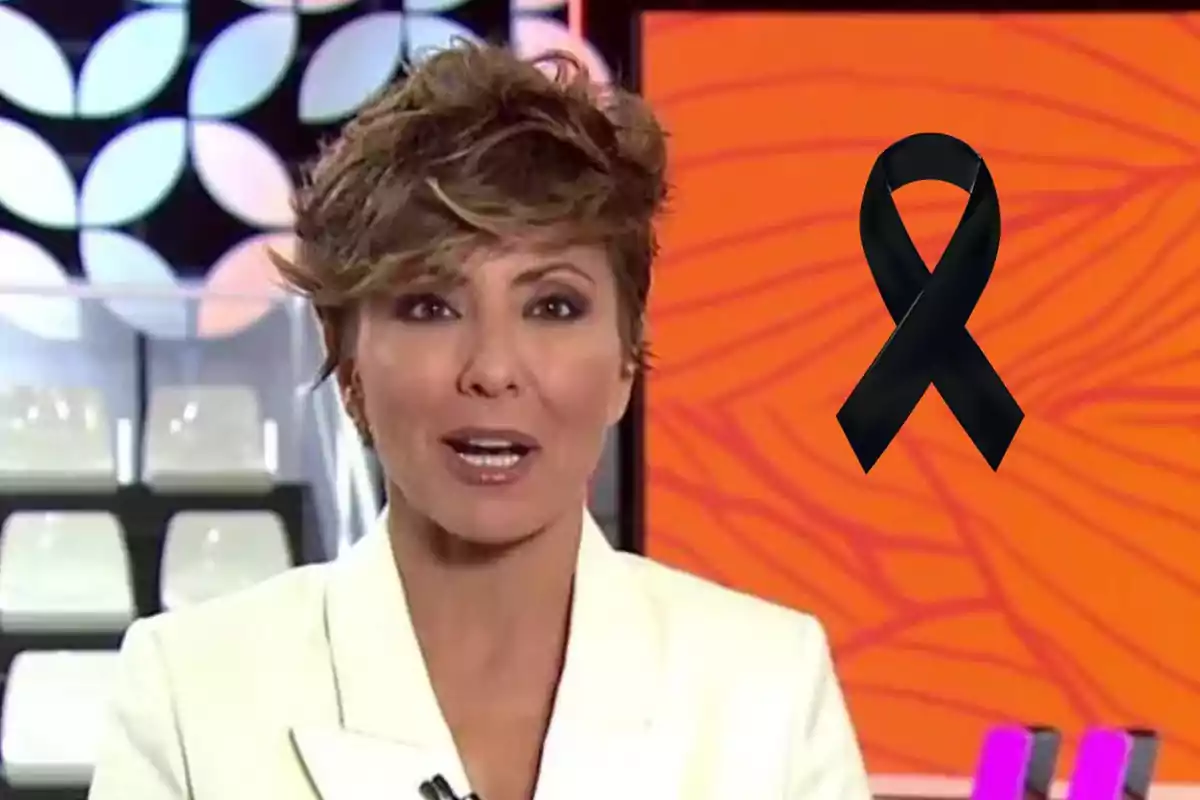 Presentadora de notícies amb fons taronja i un llaç negre de dol