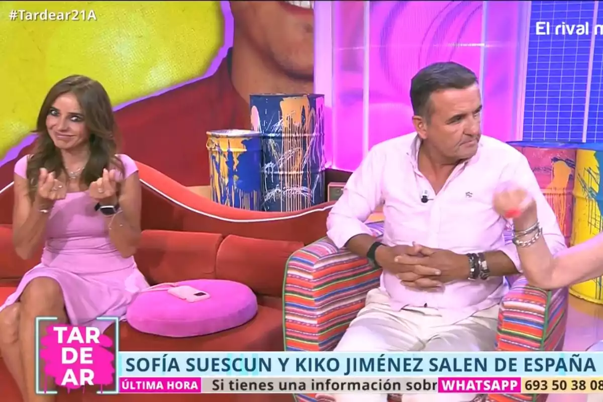 Carmen Alcayde y Antonio Montero sentados en un set de televisión colorido con decoración llamativa y pantallas de fondo, mientras conversan durante un programa llamado TardeAR Carmen Alcayde y Antonio Montero sentados en un set de televisión colorido con decoración llamativa y pantallas de fondo, mientras conversan durante un programa llamado TardeAR