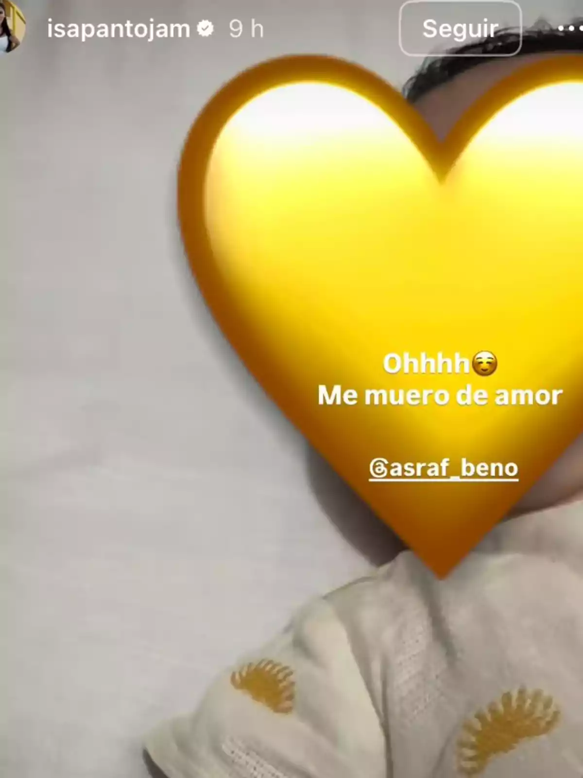 Història d’Instagram on es veu un nadó estirat amb un gran cor groc cobrint-li la cara i un text que diu Ohhhh Em moro d’amor al costat d’una menció a un altre compte Història d’Instagram on es veu un nadó estirat amb un gran cor groc cobrint-li la cara i un text que diu Ohhhh Em moro d’amor al costat d’una menció a un altre compte