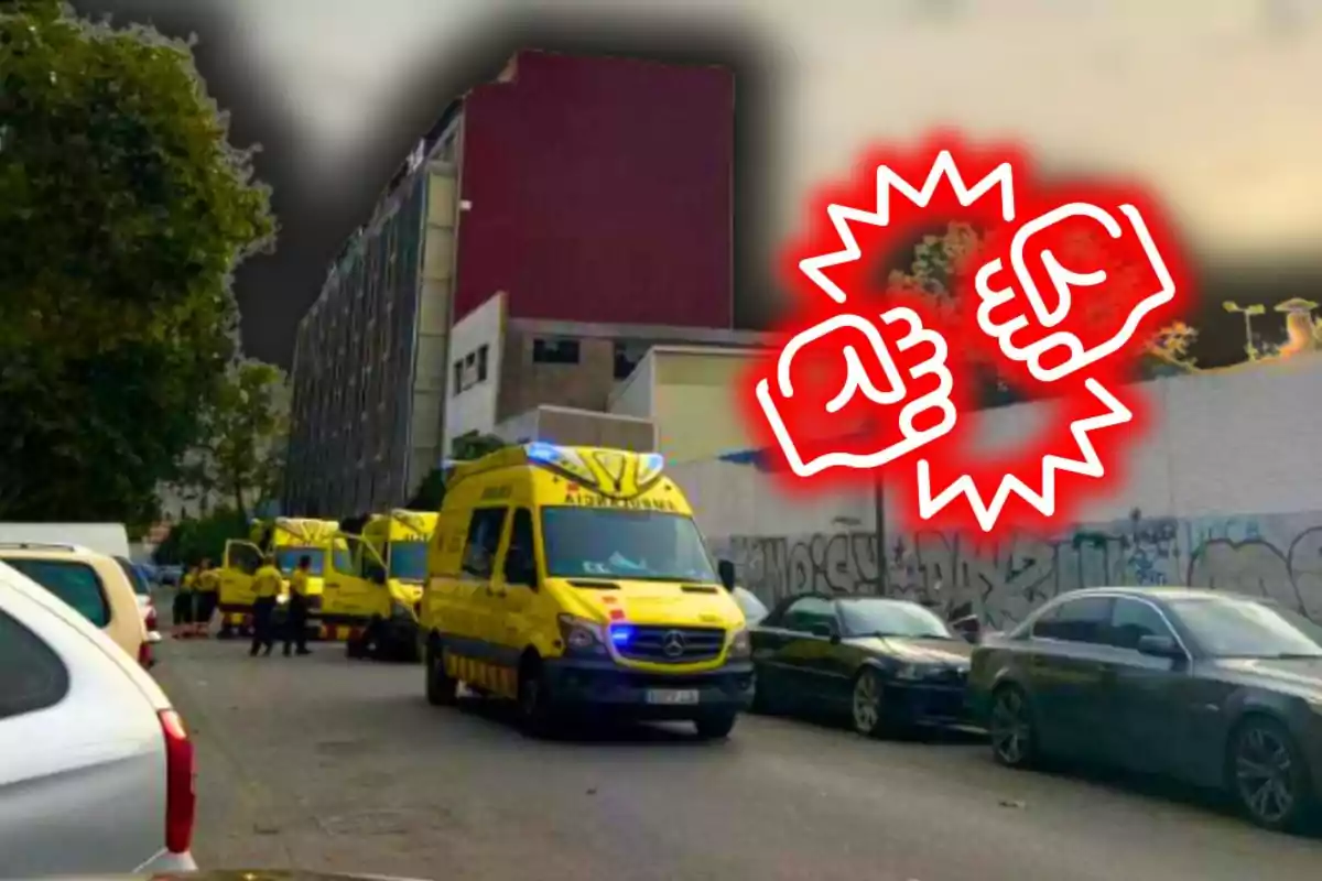 Diverses ambulàncies estacionades en un carrer al costat d’un edifici, amb un dibuix de dos punys xocant ressaltat en vermell sobre la imatge.
