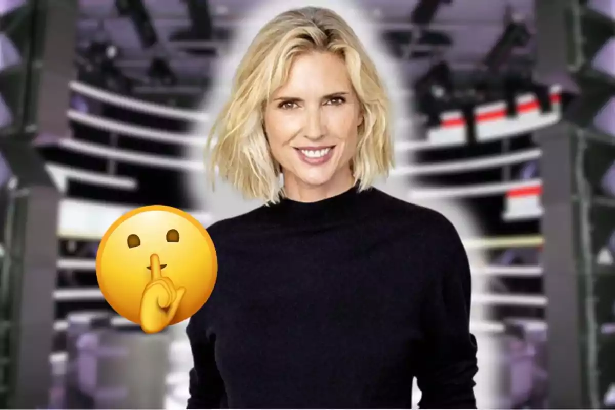Dona rossa somrient amb jersei negre davant d’un fons d’estudi de televisió i un emoji de silenci superposat.