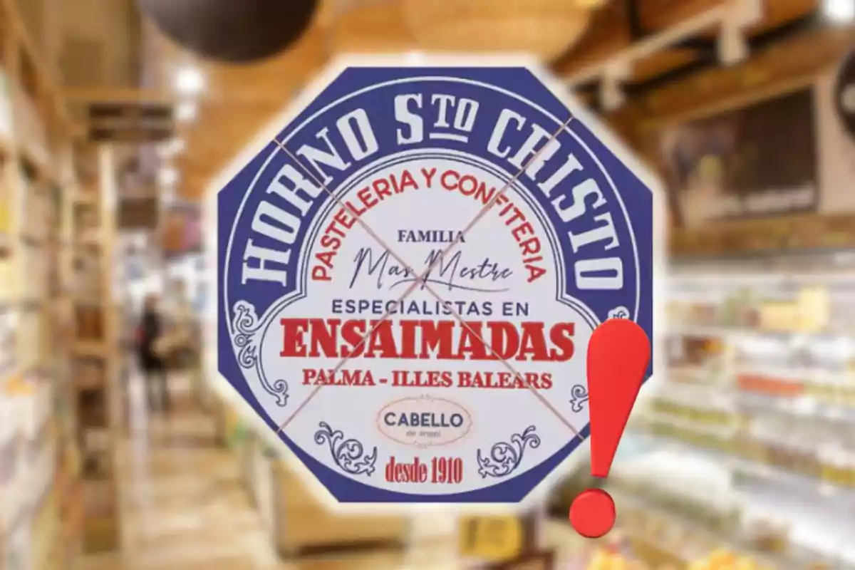 Etiqueta octagonal de una pastelería llamada Horno Santo Cristo con letras rojas y azules sobre un fondo de supermercado desenfocado y un signo de exclamación rojo a la derecha