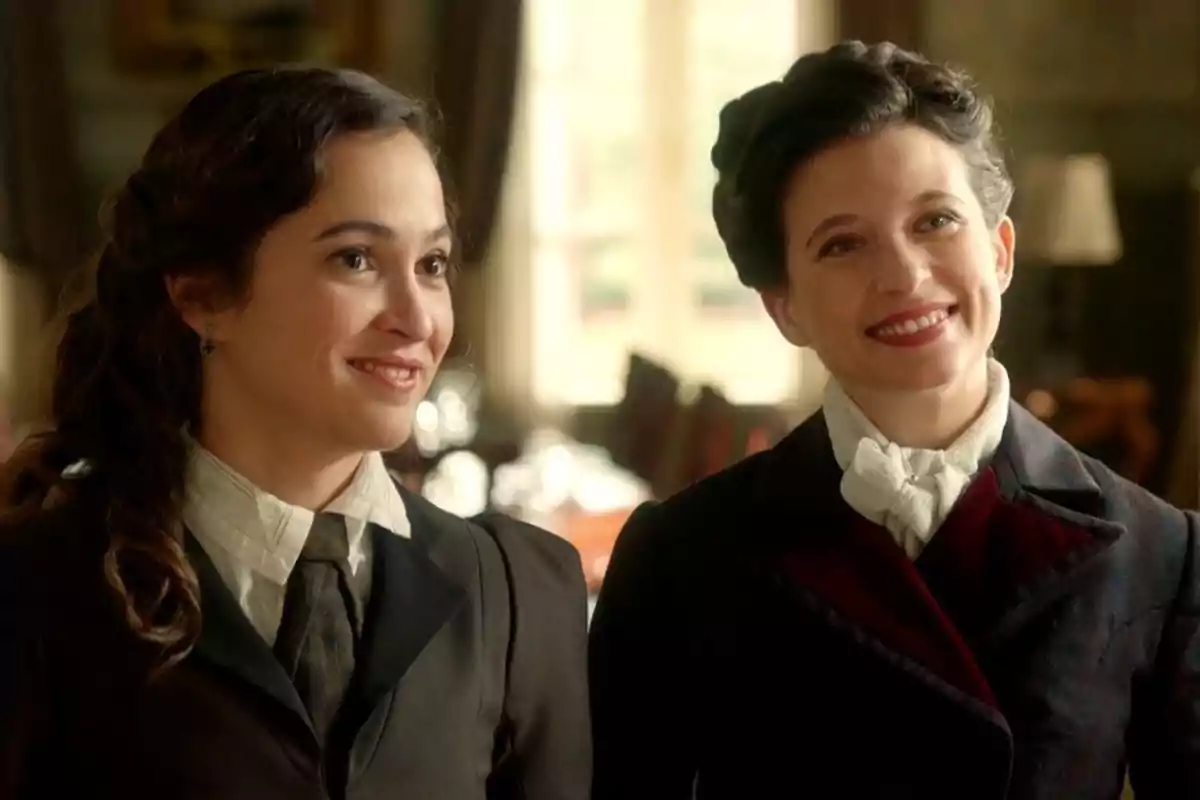 Catalina y Martina sonríen vestidas con ropa de época en un ambiente elegante y cálido. Captura de 'La Promesa' Catalina y Martina sonríen vestidas con ropa de época en un ambiente elegante y cálido. Captura de 'La Promesa'