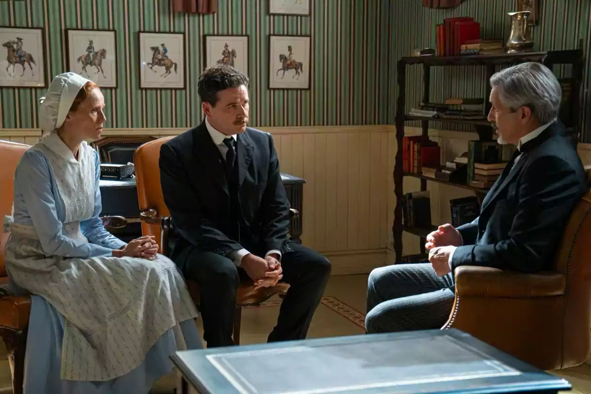 Pía, Ricardo y Cristóbal vestidas con ropa de época conversan sentadas en una oficina elegante decorada con cuadros de caballos y estanterías llenas de libros. Captura de 'La Promesa' Pía, Ricardo y Cristóbal vestidas con ropa de época conversan sentadas en una oficina elegante decorada con cuadros de caballos y estanterías llenas de libros. Captura de 'La Promesa'