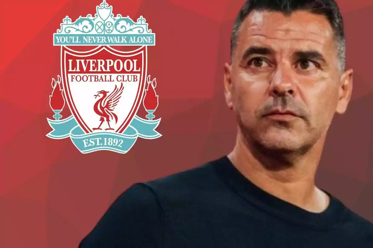 Home de cabell curt amb samarreta fosca davant de l’escut del Liverpool sobre un fons vermell