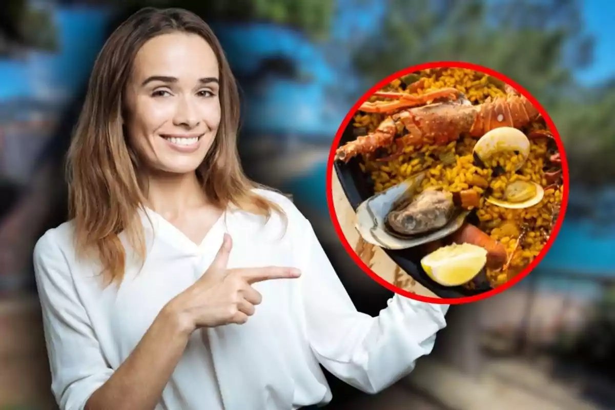 Mujer sonriente señalando una imagen circular de paella de mariscos