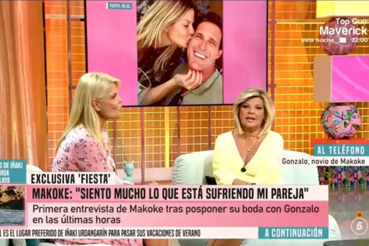 Makoke i Terelu Campos conversen en un programa de televisió amb un gran cartell informatiu sobre una entrevista exclusiva i una imatge d’una parella somrient a la pantalla de fons. Makoke i Terelu Campos conversen en un programa de televisió amb un gran cartell informatiu sobre una entrevista exclusiva i una imatge d’una parella somrient a la pantalla de fons.