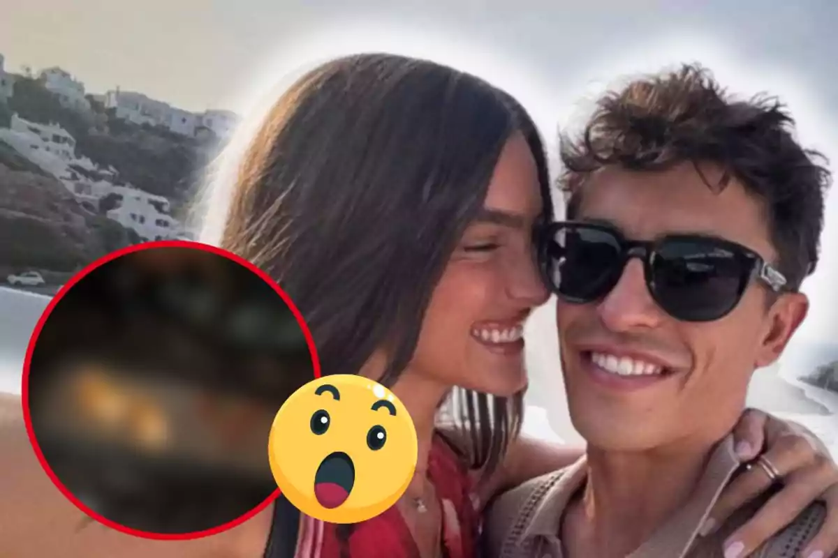 Pareja joven sonriendo y abrazándose al aire libre con casas blancas al fondo y un emoji de sorpresa en primer plano