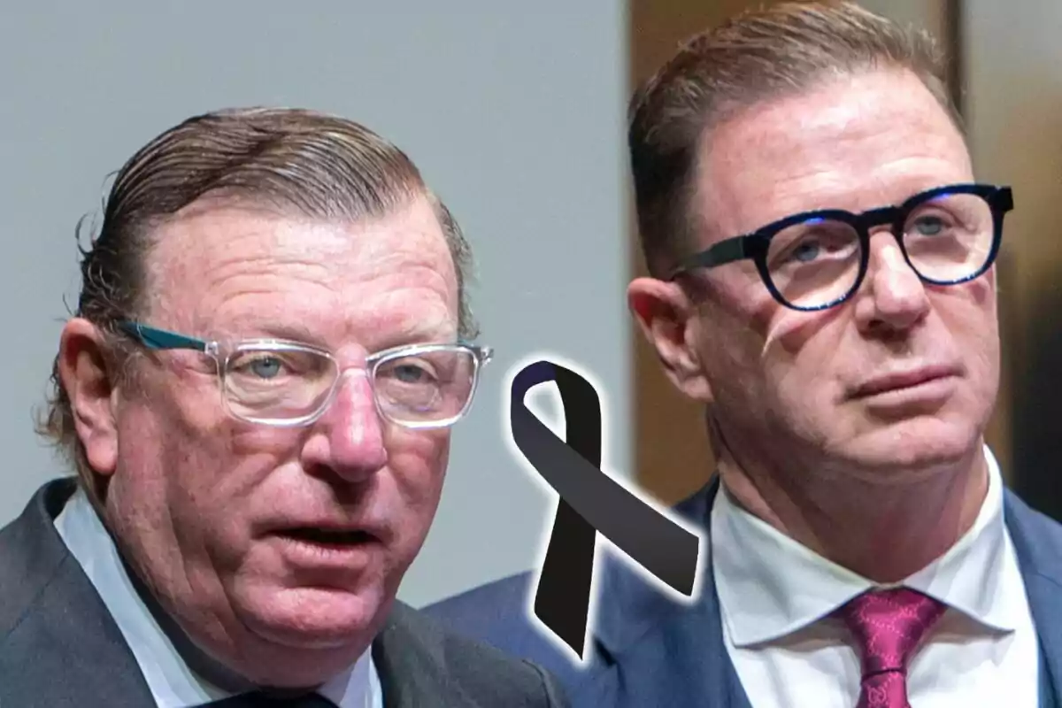Dos hombres con gafas y traje, que son Los Morancos, aparecen junto a un moño negro de luto en el centro de la imagen.