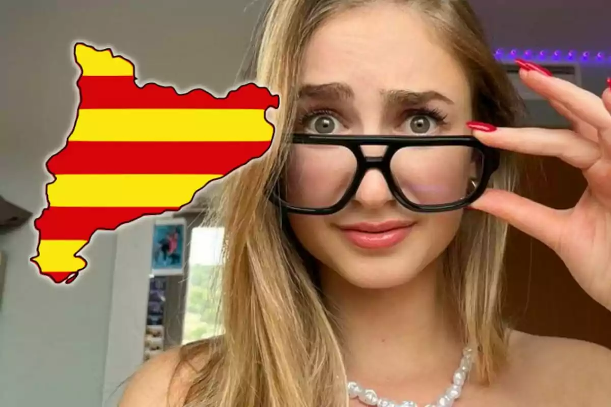 Joven con gafas grandes mirando sorprendida junto a un mapa de Cataluña con la bandera catalana