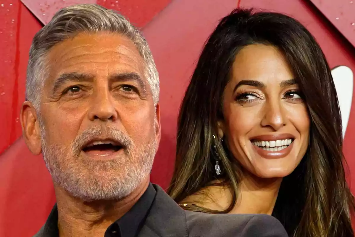 George Clooney and Amal Clooney smile in front of a red background.