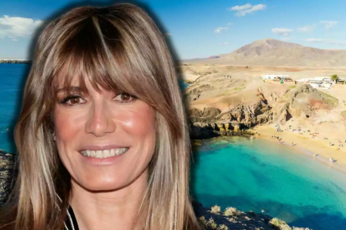 Begoña Gómez sonriente con cabello rubio frente a una playa de aguas turquesas y montañas al fondo