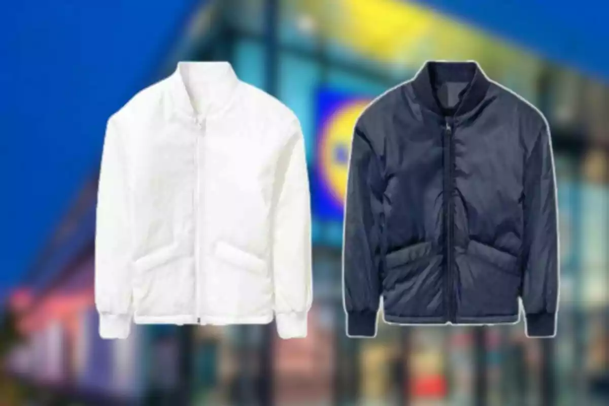 Dues jaquetes tipus bomber, una de blanca i una de blau marí, sobre un fons desenfocat d’una botiga. Dues jaquetes tipus bomber, una de blanca i una de blau marí, sobre un fons desenfocat d’una botiga.