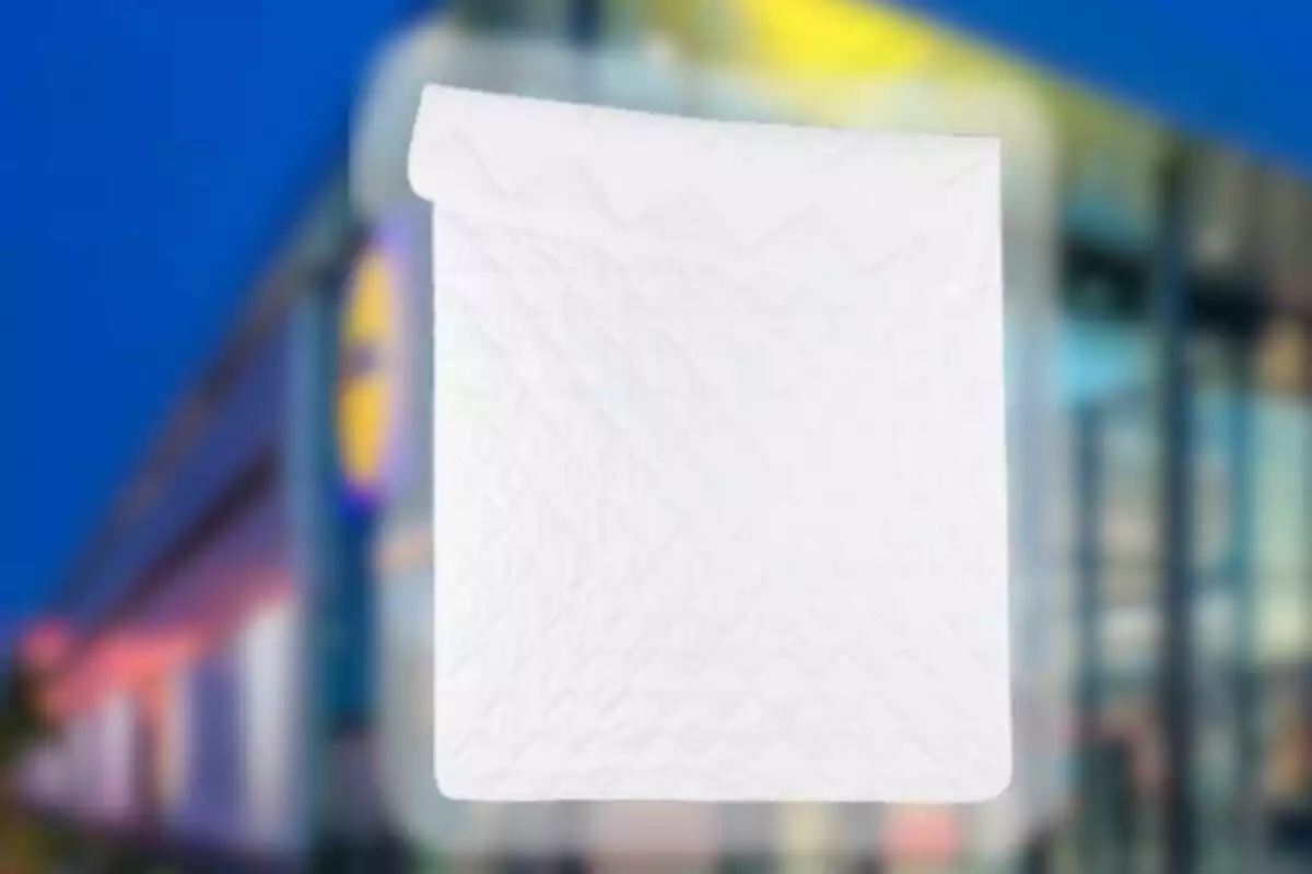 White folded quilt with a quilted design on a blurred background of a modern building. White folded quilt with a quilted design on a blurred background of a modern building.