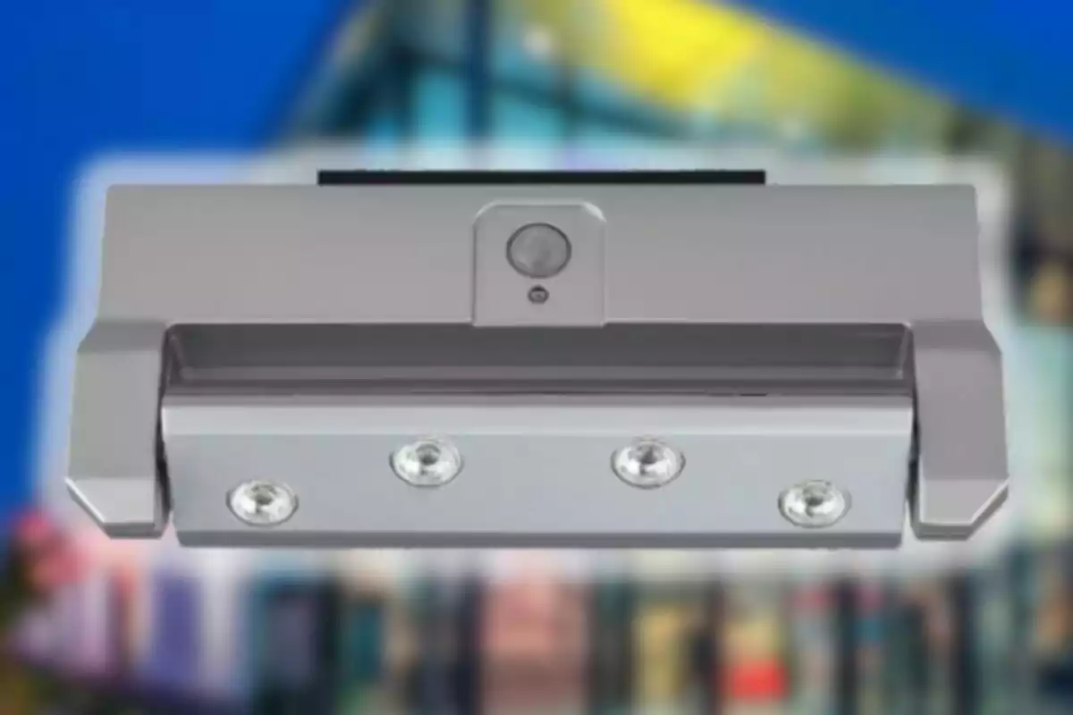 Lámpara LED gris con sensor de movimiento y cuatro focos frente a un fondo desenfocado de edificio moderno Lámpara LED gris con sensor de movimiento y cuatro focos frente a un fondo desenfocado de edificio moderno