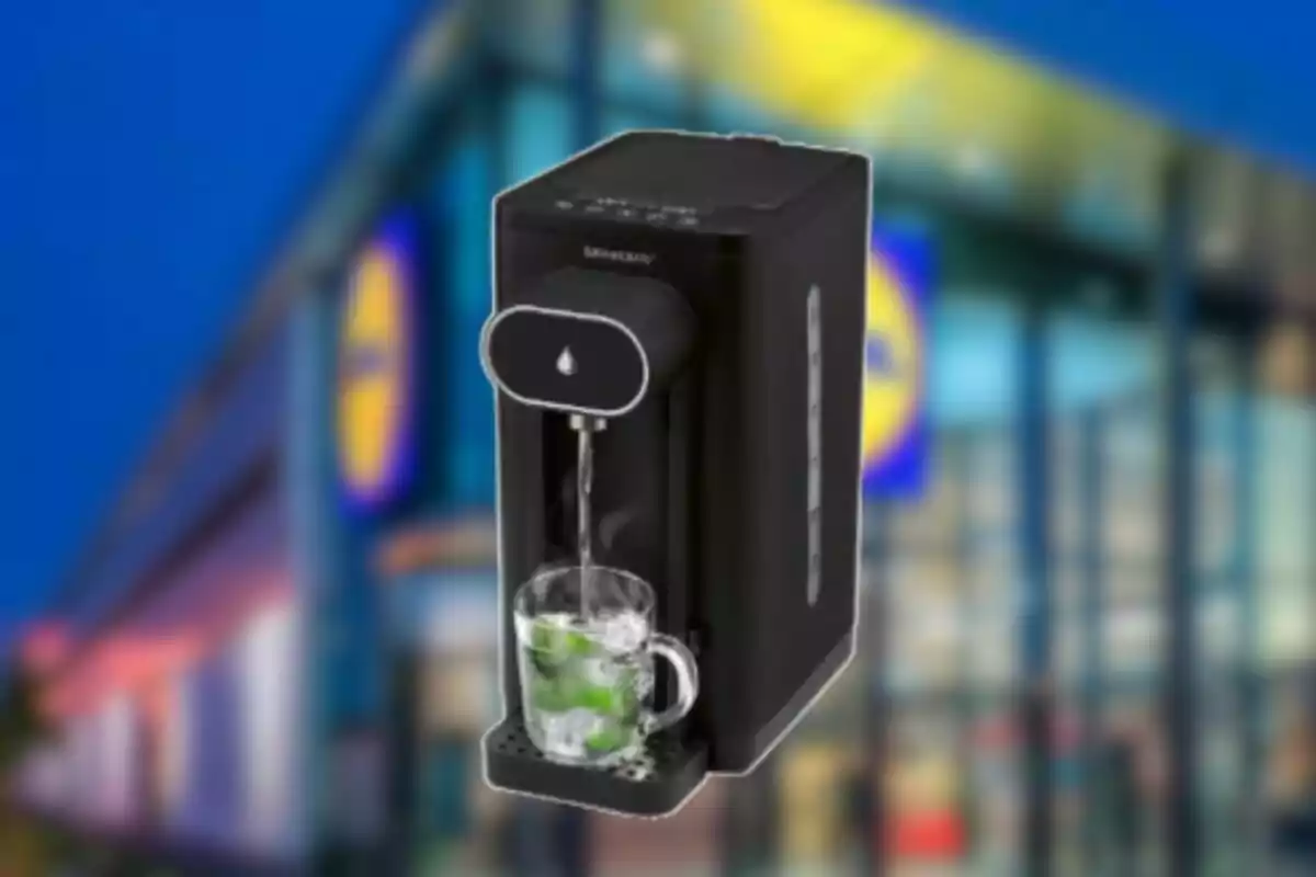 Dispensador de agua caliente negro con una taza transparente al frente de una tienda desenfocada Dispensador de agua caliente negro con una taza transparente al frente de una tienda desenfocada