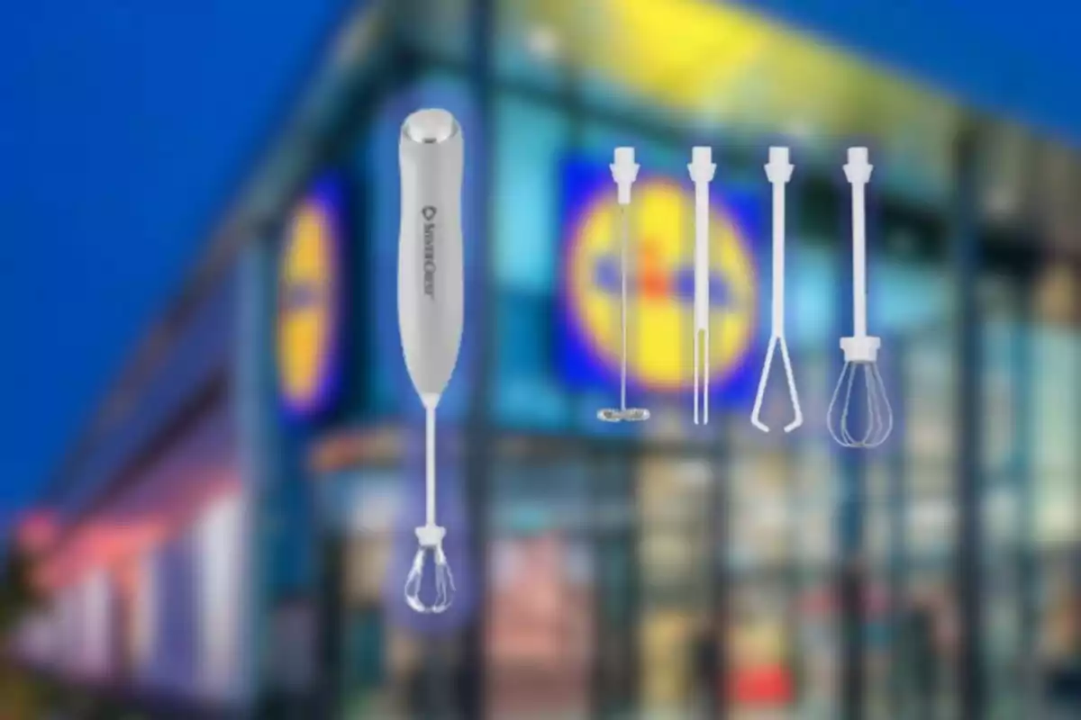 Batedora de mà blanca amb diversos accessoris davant d’una botiga amb el logotip de Lidl desenfocat al fons Batedora de mà blanca amb diversos accessoris davant d’una botiga amb el logotip de Lidl desenfocat al fons