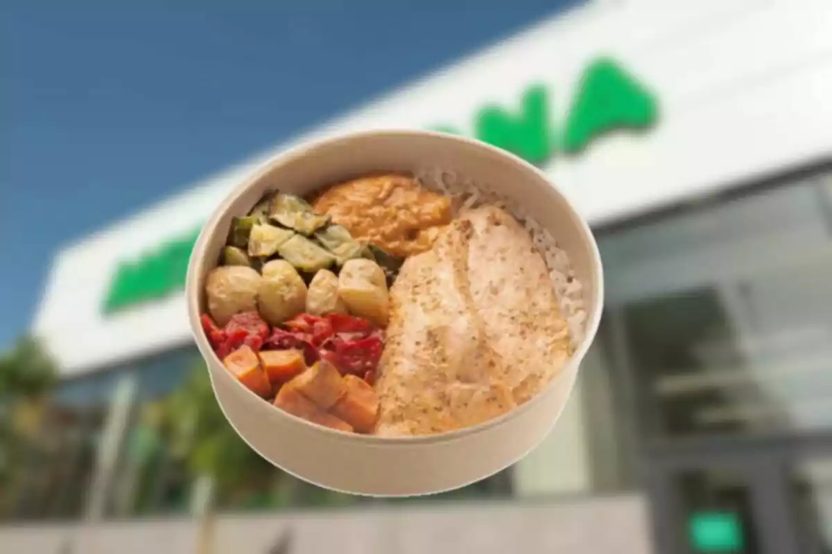 Un bol de menjar saludable amb pollastre, arròs i verdures davant d’una botiga Un bol de menjar saludable amb pollastre, arròs i verdures davant d’una botiga