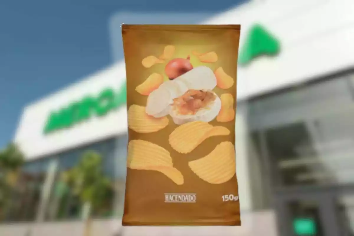 Bolsa de patatas onduladas sabor queso de cabra y cebolla caramelizada de la marca Hacendado frente a un supermercado Bolsa de patatas onduladas sabor queso de cabra y cebolla caramelizada de la marca Hacendado frente a un supermercado