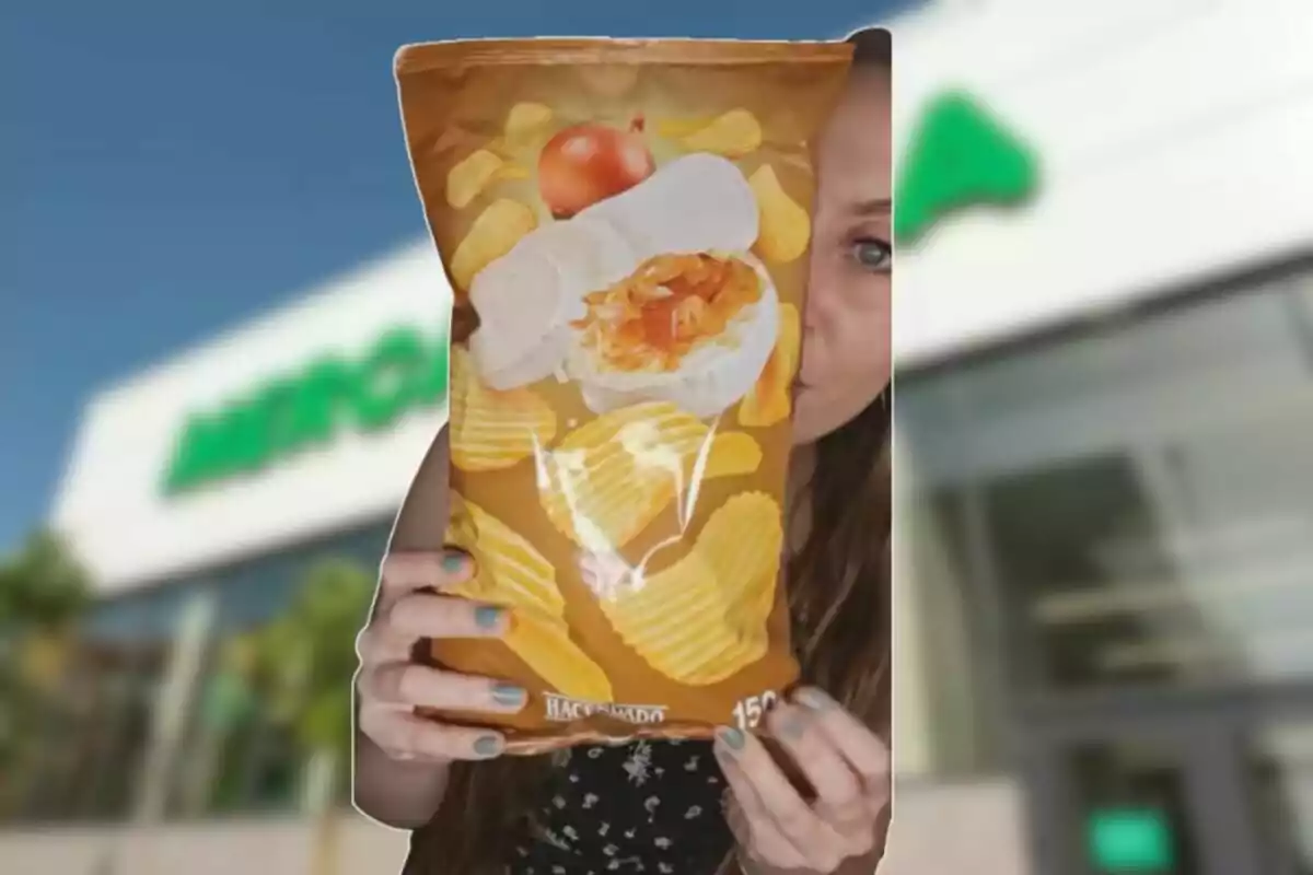 Persona sosteniendo una bolsa de papas fritas sabor queso y cebolla frente a una tienda Persona sosteniendo una bolsa de papas fritas sabor queso y cebolla frente a una tienda