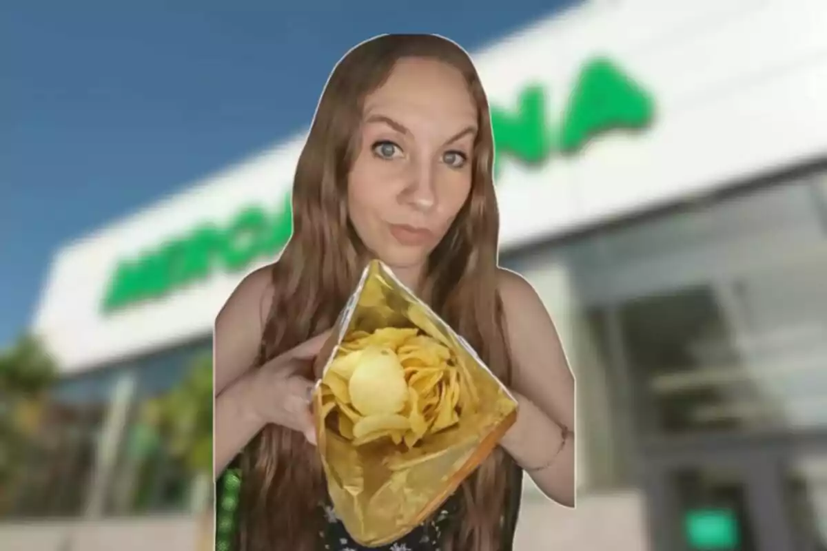 Mujer con cabello largo sostiene una bolsa abierta de papas fritas frente a un supermercado desenfocado Mujer con cabello largo sostiene una bolsa abierta de papas fritas frente a un supermercado desenfocado