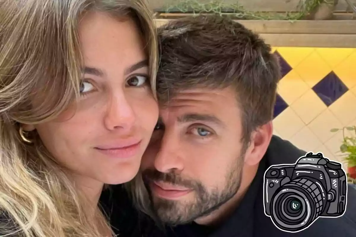 Clara Chia i Gerard Piqué posant junts i somrient suaument amb una càmera il·lustrada a la cantonada de la imatge i un fons de rajoles blanques amb detalls blaus.