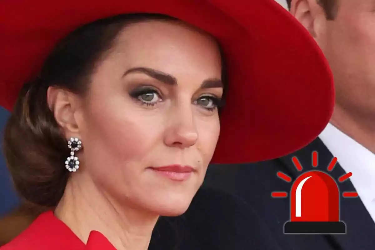 Kate Middleton amb barret vermell i arracades elegants mirant al front amb una icona d'alarma vermella a la cantonada inferior dreta