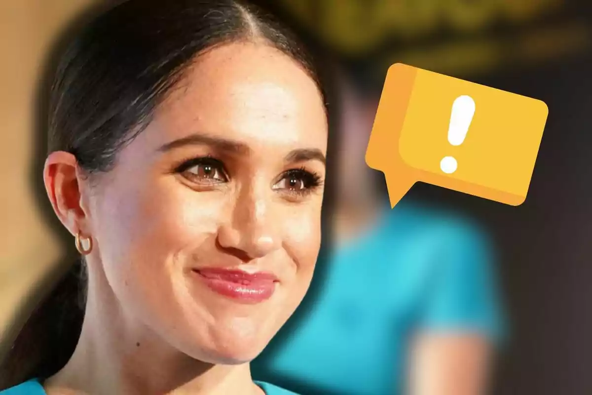 Meghan Markle sonriente con el cabello recogido y un ícono de mensaje amarillo con signo de exclamación a su lado