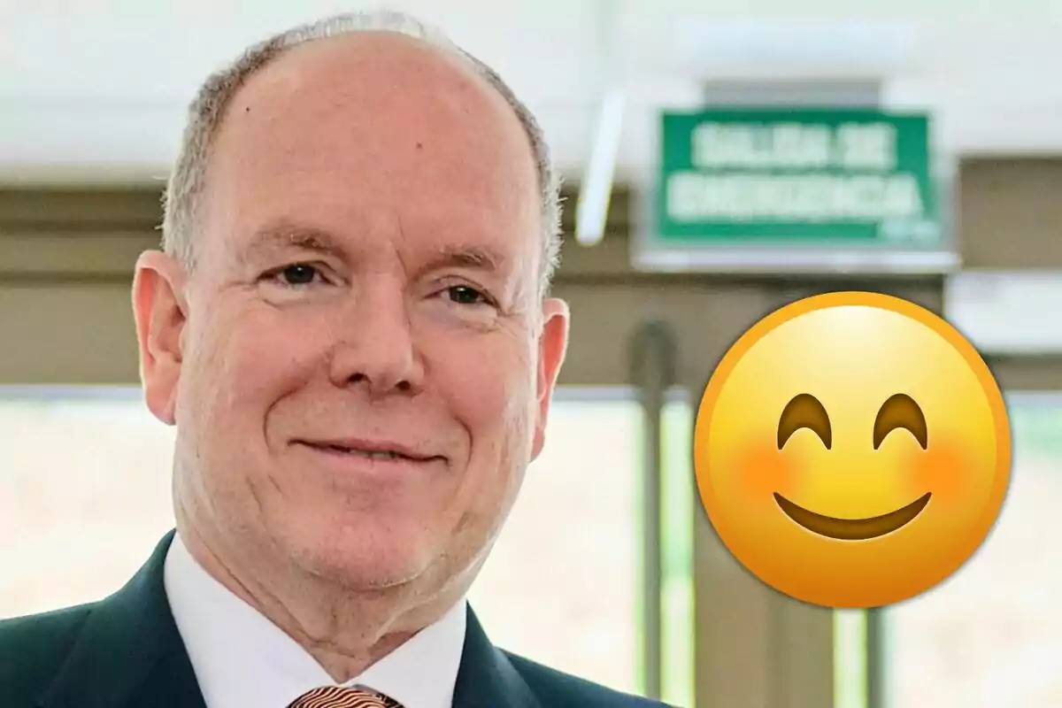 Alberto de Mònaco amb vestit somrient amb un gran emoji somrient al costat i un rètol de sortida d’emergència al fons
