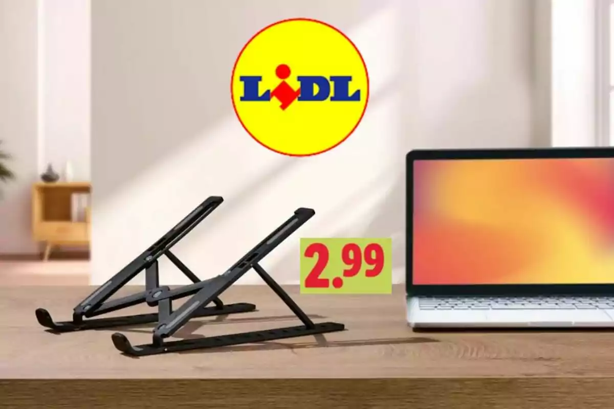Suport negre per a portàtil sobre una taula al costat d’un ordinador portàtil amb el logotip de Lidl i el preu 2,99 en primer pla Suport negre per a portàtil sobre una taula al costat d’un ordinador portàtil amb el logotip de Lidl i el preu 2,99 en primer pla