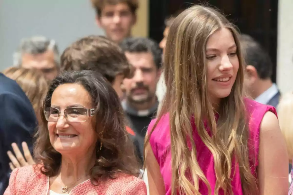 Paloma Rocasolano i la infanta Sofia somriuen mentre estan envoltades d’altres persones en un esdeveniment a l’aire lliure. Paloma Rocasolano i la infanta Sofia somriuen mentre estan envoltades d’altres persones en un esdeveniment a l’aire lliure.