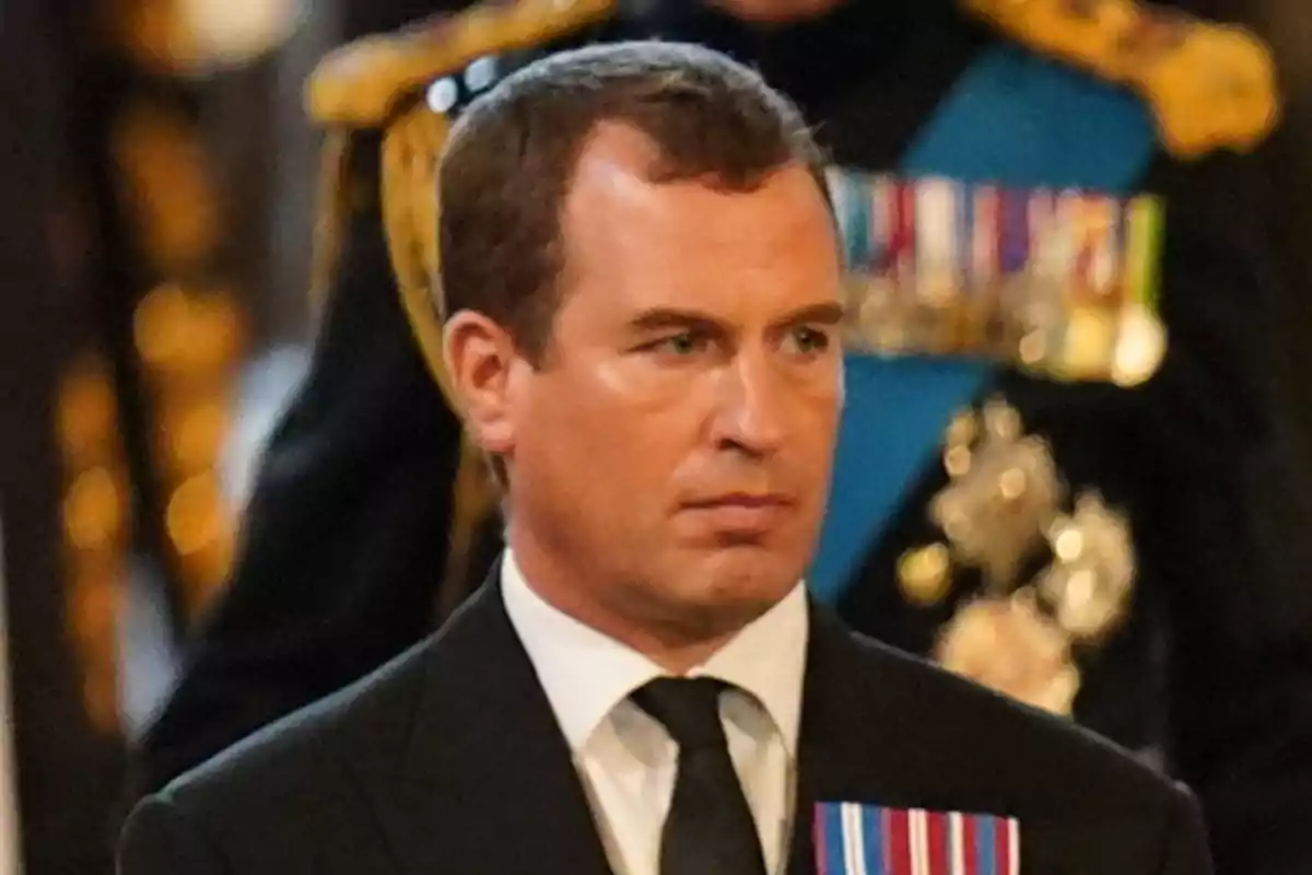 Peter Phillips in a dark suit with a black tie and medals on his chest at a formal event Peter Phillips in a dark suit with a black tie and medals on his chest at a formal event