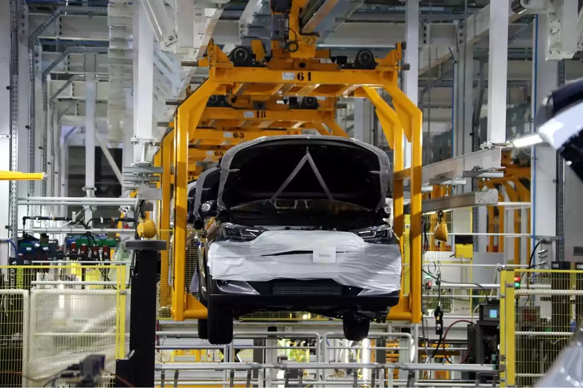 Automóvil en proceso de ensamblaje en una línea de producción industrial dentro de una fábrica Automóvil en proceso de ensamblaje en una línea de producción industrial dentro de una fábrica