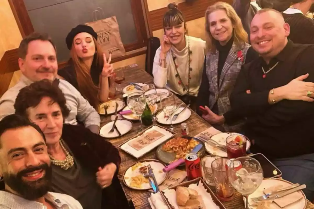 Un grupo de personas sonríe y posa para una foto mientras disfrutan de una comida en un restaurante, con platos y bebidas sobre la mesa. Un grupo de personas sonríe y posa para una foto mientras disfrutan de una comida en un restaurante, con platos y bebidas sobre la mesa.