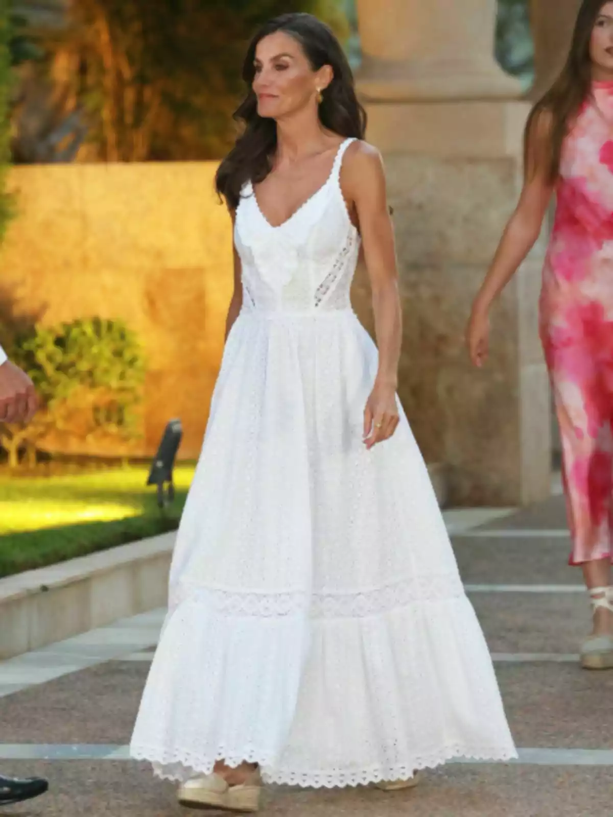 La reina Letizia con vestido largo blanco de tirantes y sandalias beige caminando al aire libre La reina Letizia con vestido largo blanco de tirantes y sandalias beige caminando al aire libre