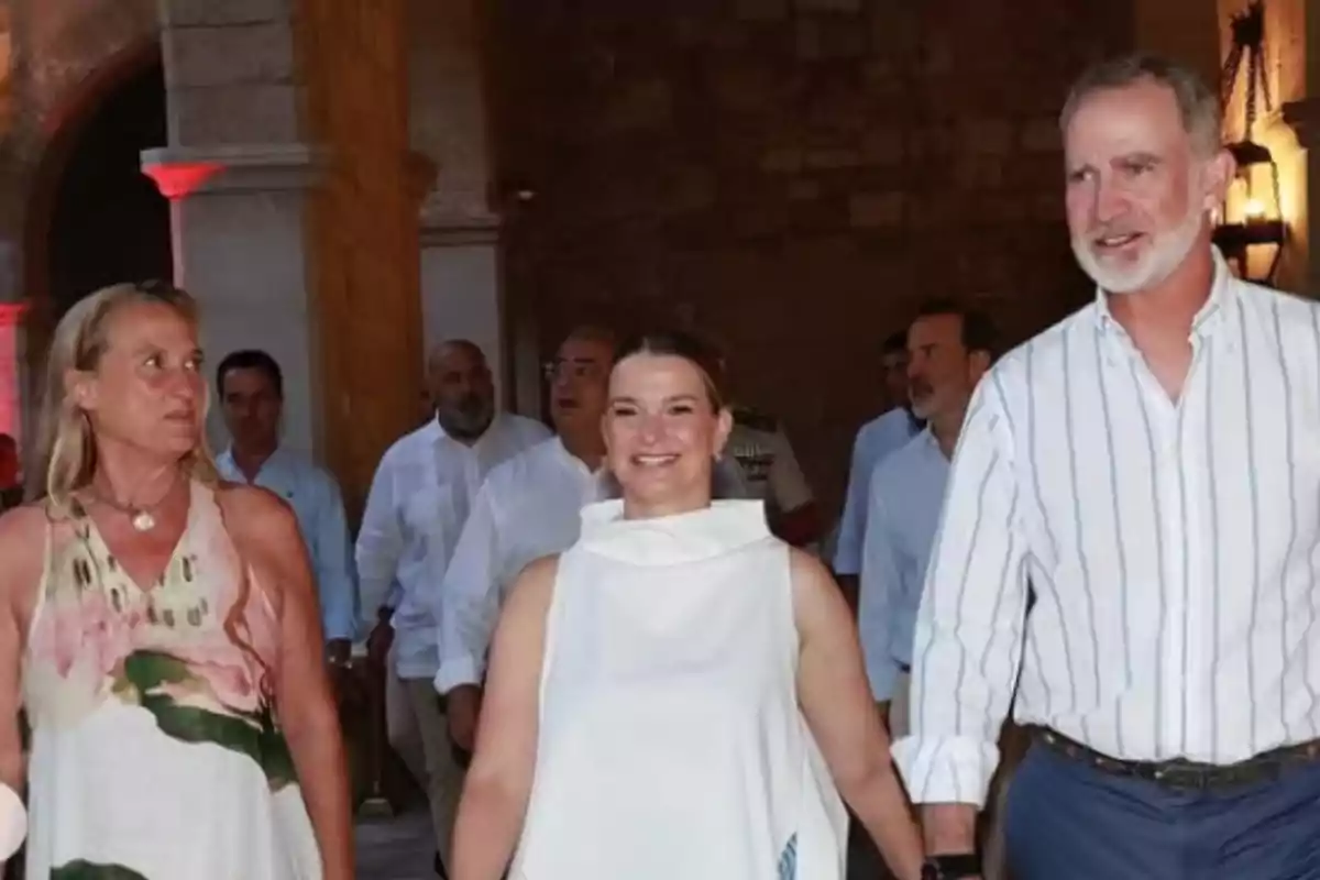Felip VI, amb camisa blanca de ratlles blaves i pantalons blaus, passeja amb dues dones pel Palau de l'Almudaina, de Palma. Felip VI, amb camisa blanca de ratlles blaves i pantalons blaus, passeja amb dues dones pel Palau de l'Almudaina, de Palma.