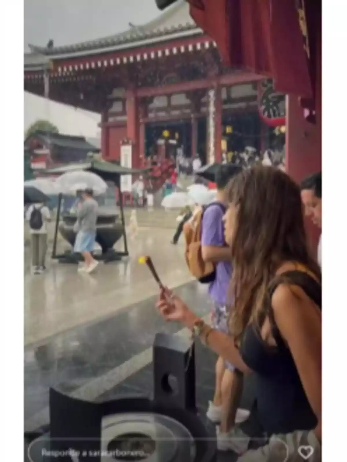 Sara Carbonero sostenint un encens davant d’un temple japonès mentre plou i diverses persones fan servir paraigües Sara Carbonero sostenint un encens davant d’un temple japonès mentre plou i diverses persones fan servir paraigües