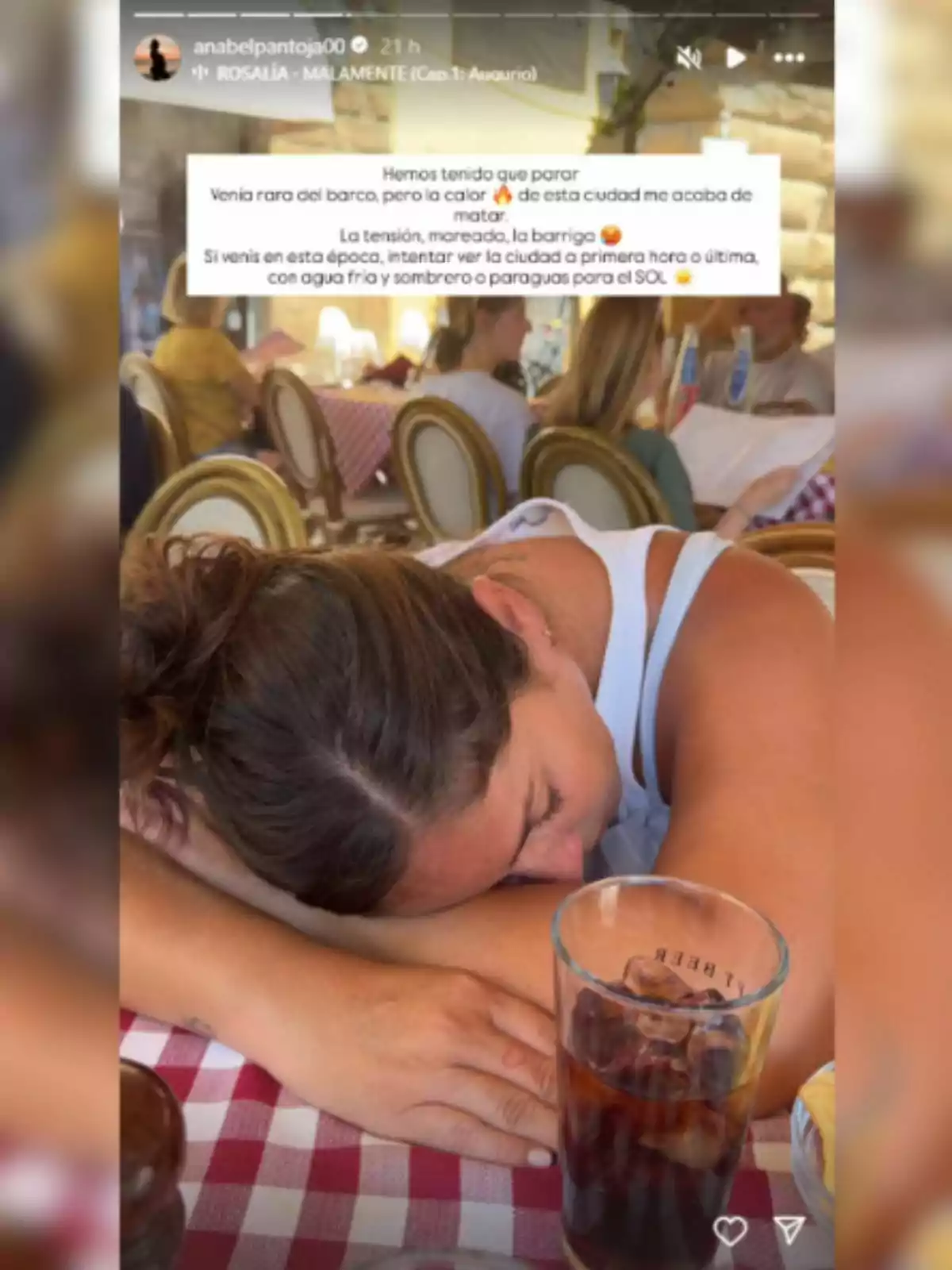 Anabel Pantoja estirada sobre una taula amb estovalla de quadres vermells i blancs en un restaurant, amb un got de refresc amb gel en primer pla i persones assegudes al fons. Anabel Pantoja estirada sobre una taula amb estovalla de quadres vermells i blancs en un restaurant, amb un got de refresc amb gel en primer pla i persones assegudes al fons.