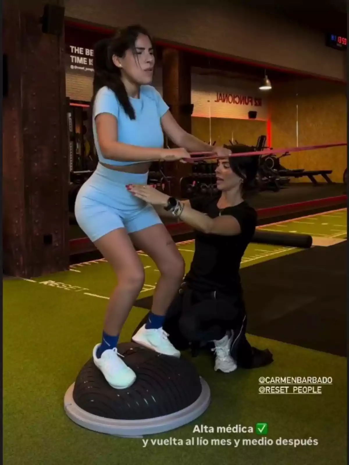 Story de Isa Pantoja, donde se la ve con ropa deportiva azul realizando un ejercicio de equilibrio sobre una plataforma inestable mientras una entrenadora la asiste en un gimnasio